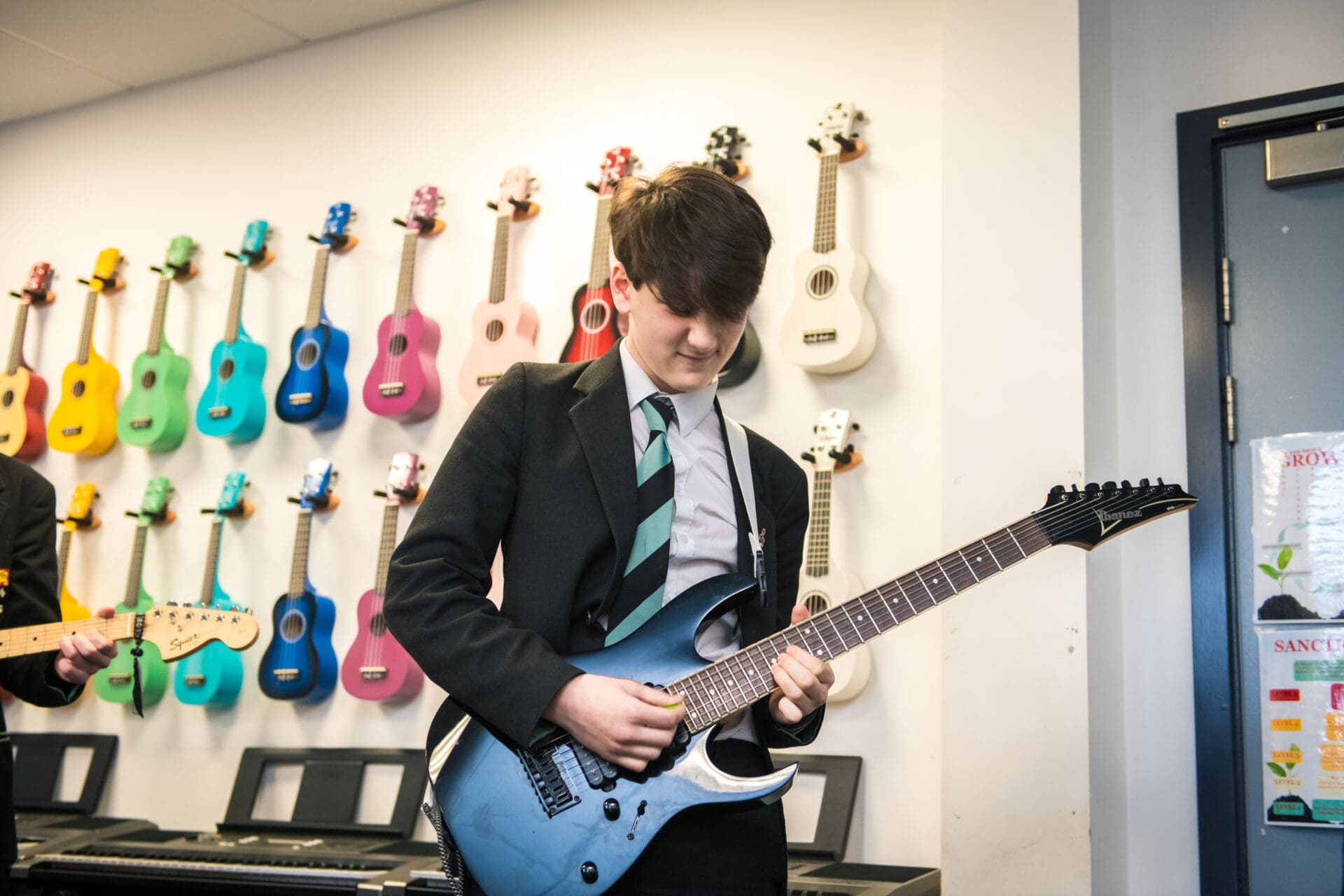 Image of a male student playing a guitar