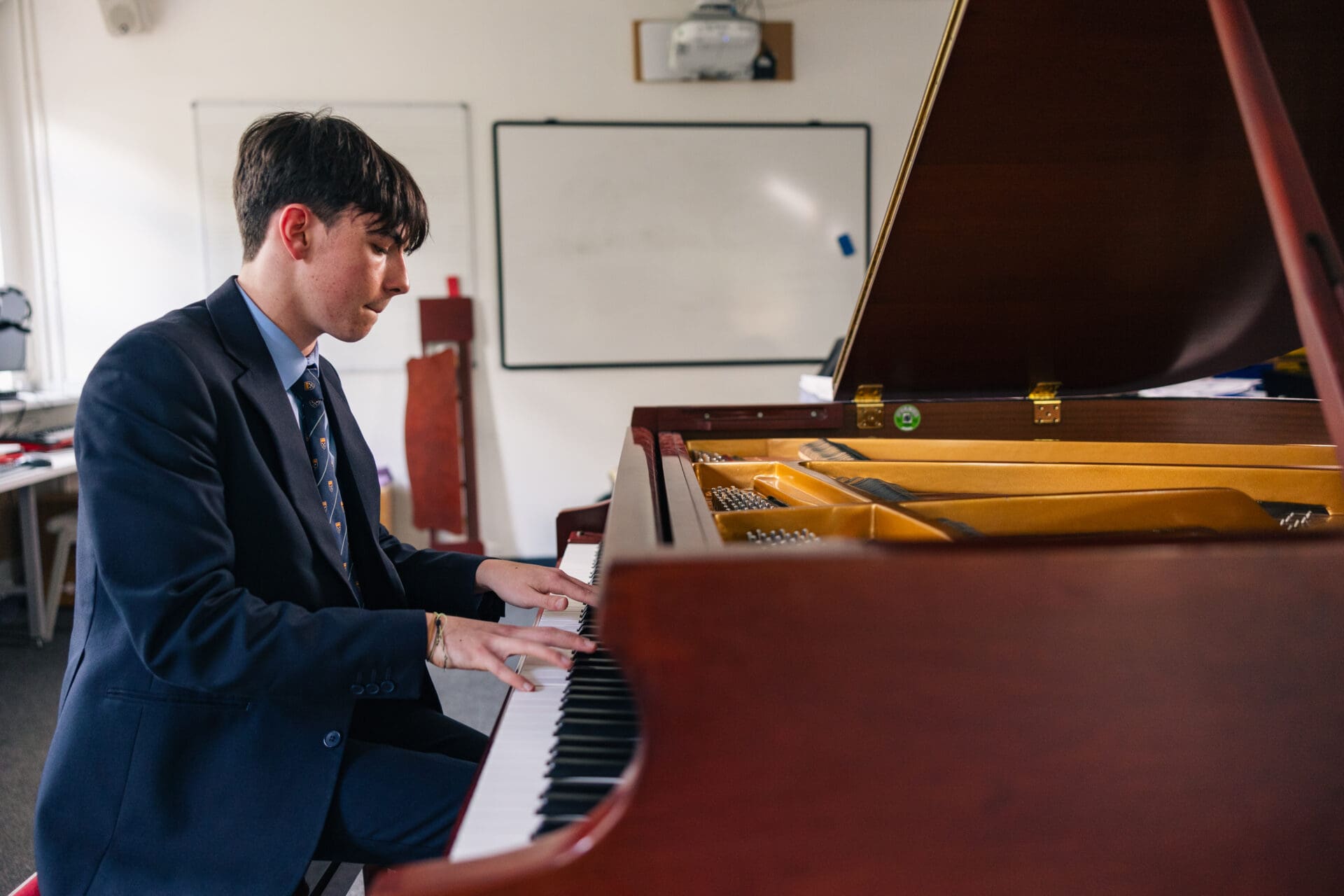 Image of a male pupil playing the piano