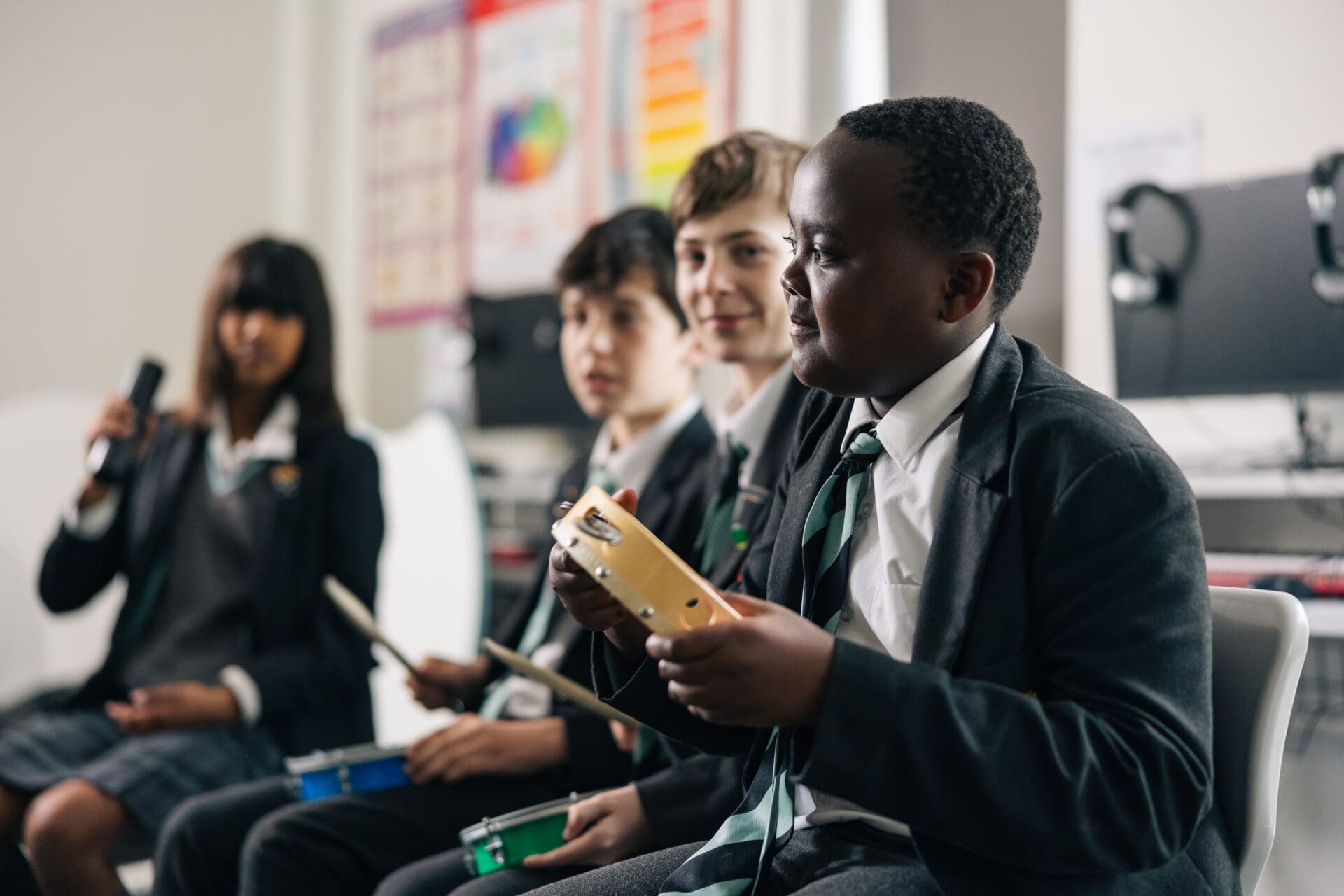Image of pupils sitting with percussion instruments in a music lesson