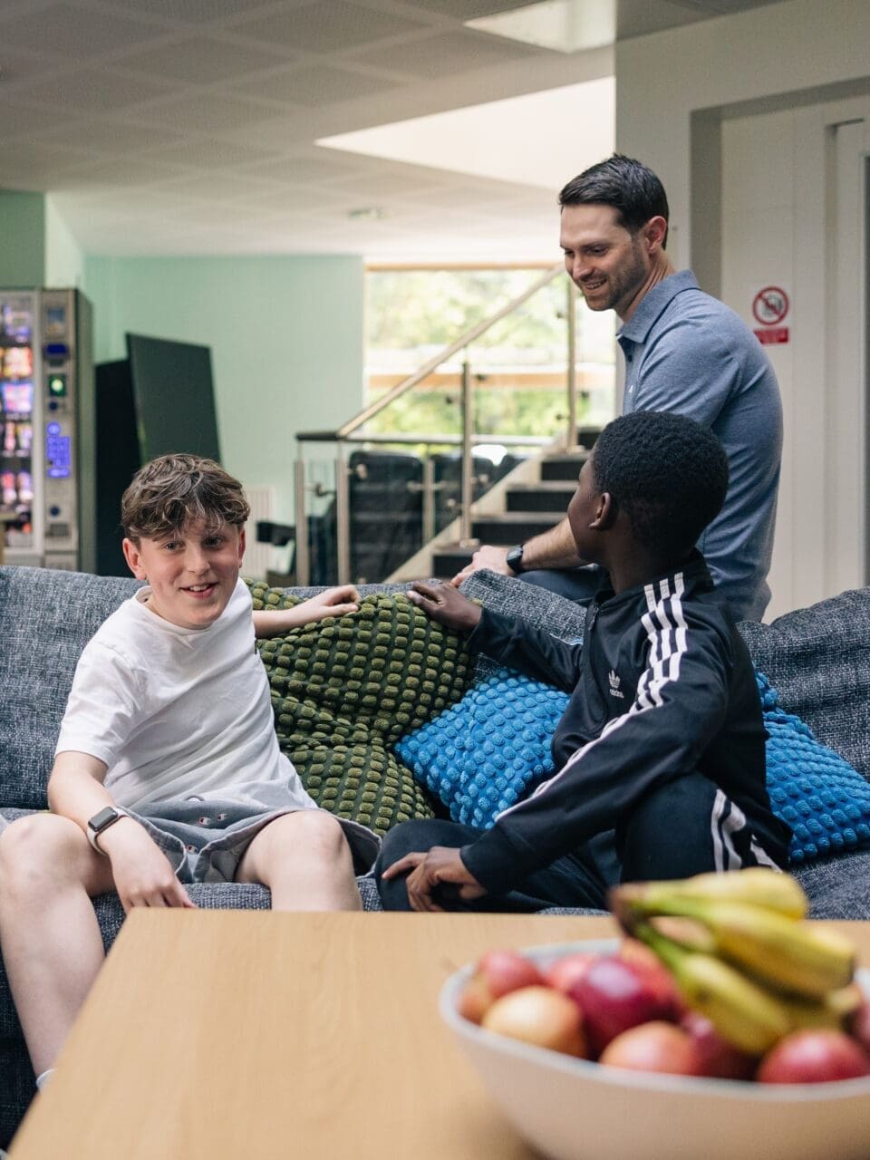 Image of pupils and teacher sat talking in their boarding house common room