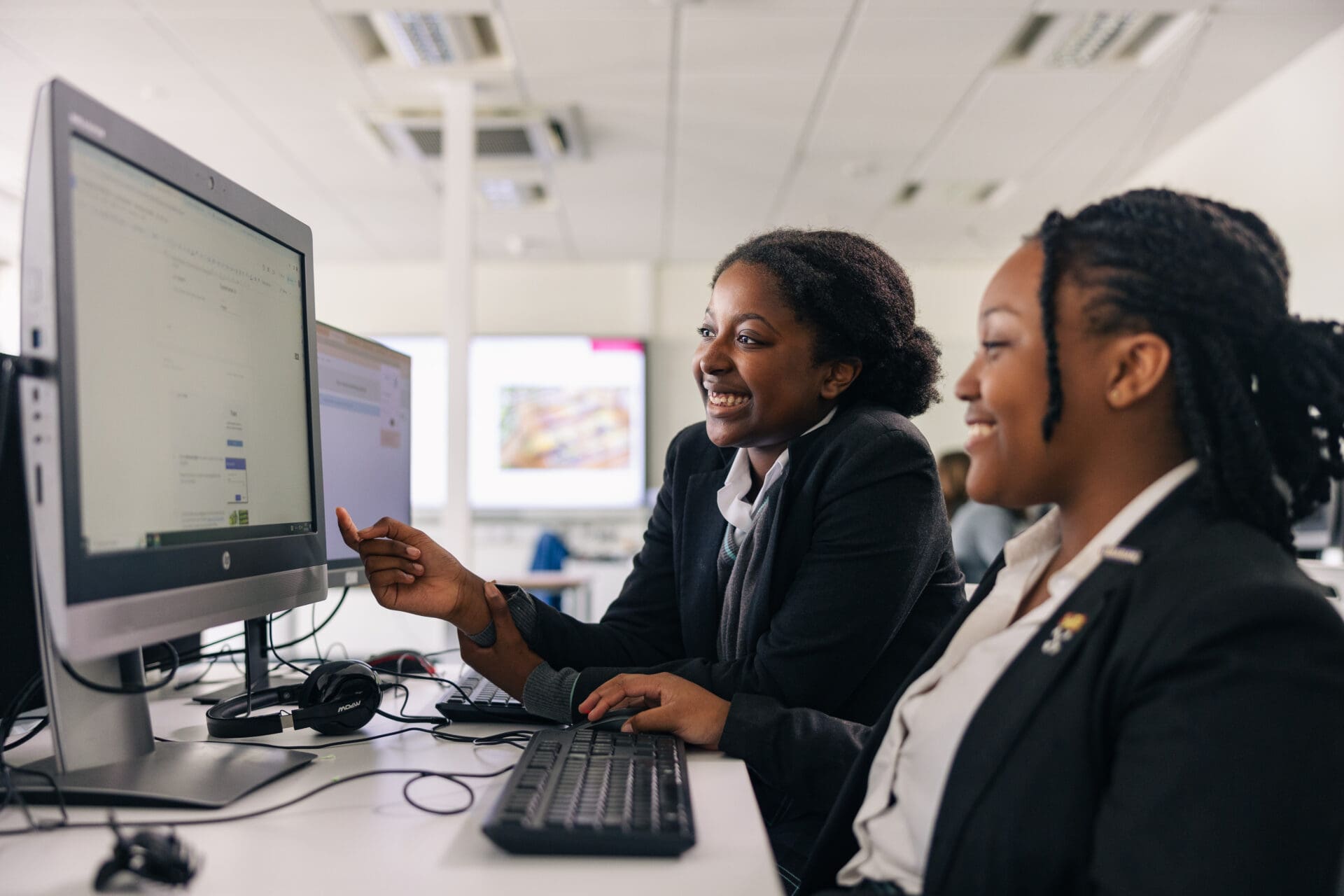 Image of pupils working at a computer screen in a computing lesson 