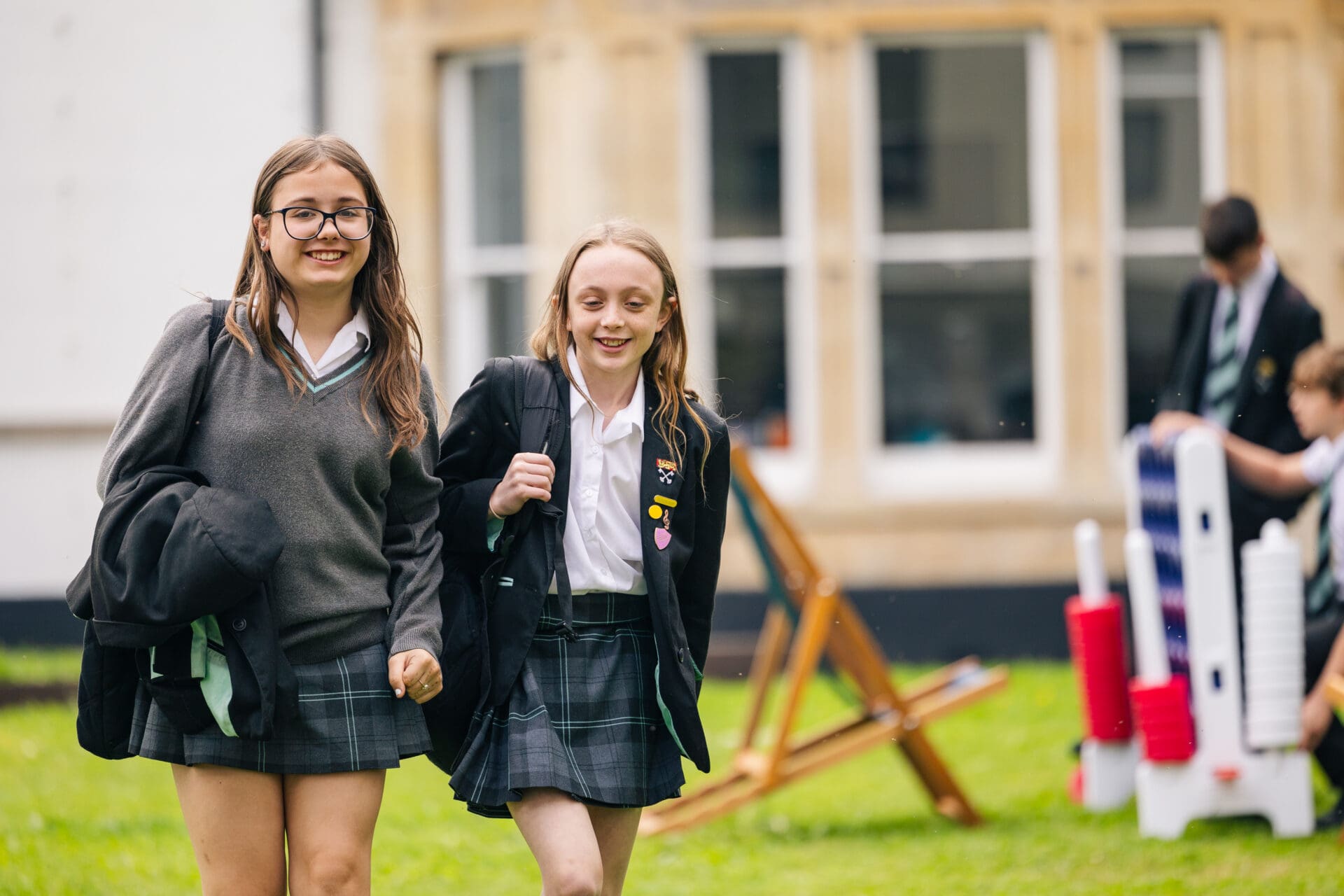 Image of 2 female pupils walking through the grounds