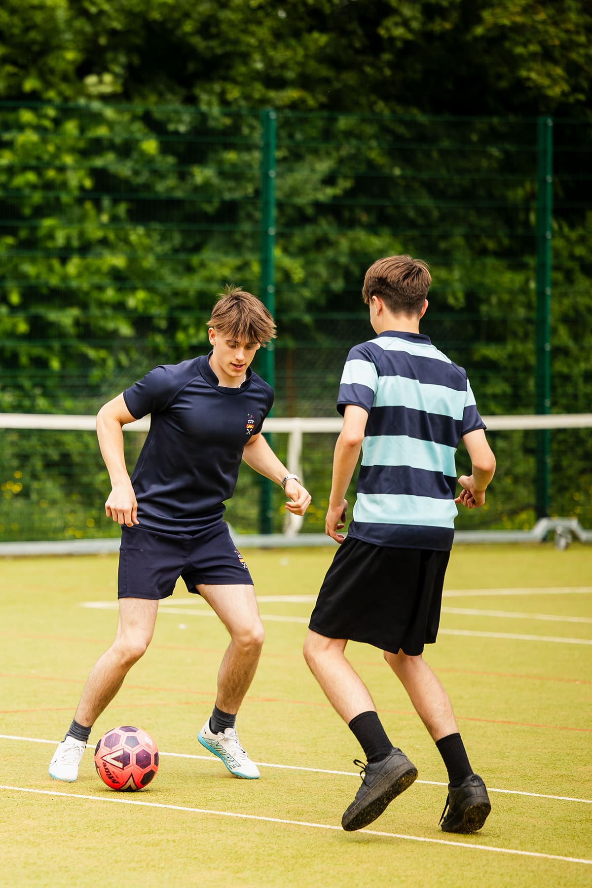 Image of 2 male pupils playing football